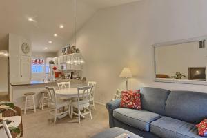 un salon avec un canapé et une table et une cuisine dans l'établissement Charlevoix Creekside Condo, à Charlevoix