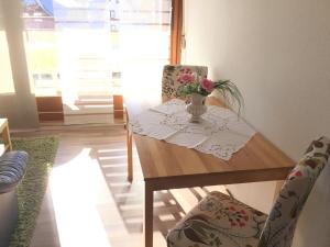 a dining room table with a vase of flowers on it at 1Z. FeWo 231 barbo Schwimmbad-Sauna-Fitness in Schonwald im Schwarzwald