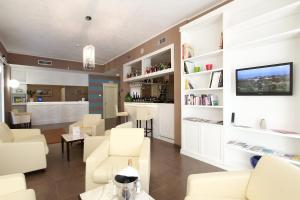 a living room with white furniture and a tv at Hotel Margherita in Monterosso al Mare
