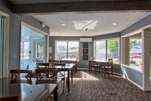 a dining room with tables and chairs and windows at 106 Pointes North Inn in Charlevoix