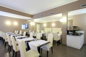 a dining room with white tables and white chairs at Hotel Margherita in Monterosso al Mare