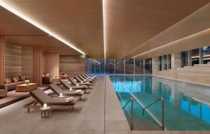 uma piscina com uma fila de cadeiras ao lado em Hyatt Regency Beijing Wangjing em Pequim