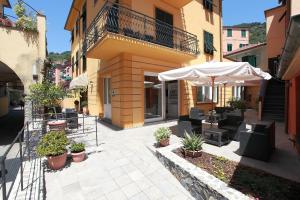 a patio with an umbrella and tables and chairs at Hotel Margherita in Monterosso al Mare