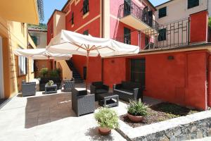 an outdoor patio with chairs and an umbrella at Hotel Margherita in Monterosso al Mare