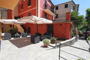 a patio with chairs and umbrellas in front of a building at Hotel Margherita in Monterosso al Mare
