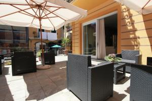 a patio with tables and chairs and an umbrella at Hotel Margherita in Monterosso al Mare
