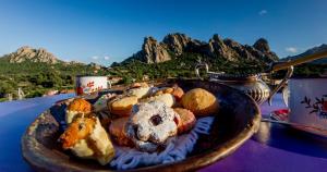a plate of food on a table with mountains in the background at Antica Dimora La Corona in San Pantaleo