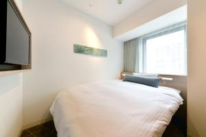 Postel nebo postele na pokoji v ubytování Vessel Inn Sakae Station