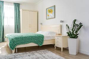 Un dormitorio con una cama y una planta en maceta. en KApartments, en Varna