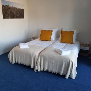 um quarto com 2 camas com almofadas laranja em B&b Broodhuis Kerkrade em Kerkrade