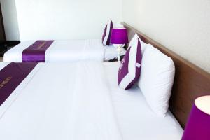 two beds in a hotel room with a purple lamp at Hai Ba Trung Hotel & Spa in Buon Ma Thuot