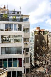 ein großes Apartmenthaus mit Bäumen davor in der Unterkunft Emerald Suite in Athen