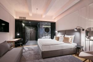 a hotel room with a bed and a desk and a bedroom at Pytloun Boutique Hotel Prague in Prague
