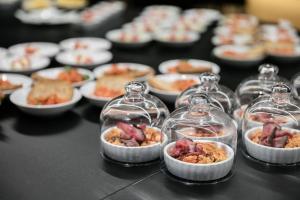 a table with plates of food in glass jars at Pytloun Boutique Hotel Prague in Prague