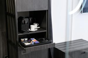 a room with a cupboard with a coffee maker at Pytloun Boutique Hotel Prague in Prague