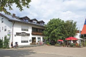 a white building with people sitting outside of it at HopfenErlebnisHof in Altmannstein