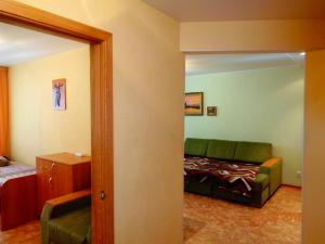トムスクにあるApartment on Uchebnaya 7/1のリビングルーム(緑のソファ、ベッド付)