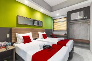 twee bedden in een kamer met groen en rood bij RedDoorz Plus @ Jones Avenue Cebu in Cebu City