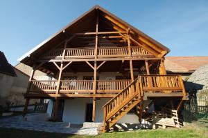 een groot houten huis met een groot terras bij Chambr'im Leh in Hoerdt