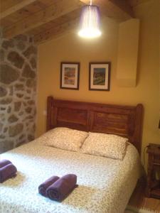ein Schlafzimmer mit einem Bett mit zwei lila Handtüchern darauf in der Unterkunft La plaza in Villatoro