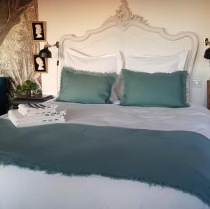 a bed with blue and white sheets and pillows at lodge-bélvédere sur les hauteurs de vichy in Vichy