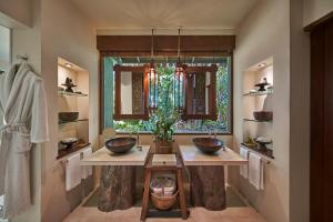 a bathroom with two sinks and a window at Song Saa Private Island in Song Saa Private Island