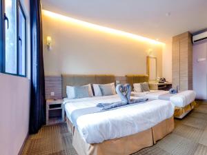 GM Grand Moments Bandar Sunway في بيتالينغ جايا: غرفة فندق بسريرين عليها حيوانات محشوة زرقاء