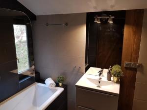 a bathroom with a sink and a tub and a mirror at Osada Knurów in Knurów