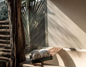 a bench with two pillows on it next to a window at Song Saa Private Island in Song Saa Private Island