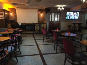 a restaurant with tables and chairs and a screen at Kilford Arms in Kilkenny