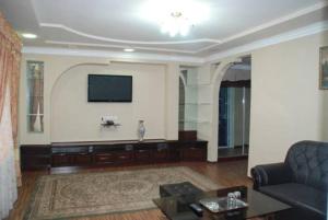 a living room with a couch and a flat screen tv at Toshkent Hotel in Andijan