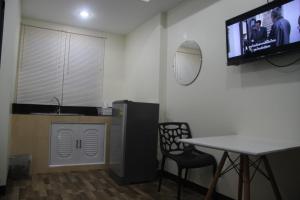 a kitchen with a table and a tv on the wall at SAB Residence in Pattaya South