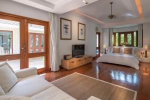 een woonkamer met een bed en een televisie bij Villa Macaque and Villa Languor in Railay Beach