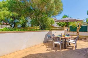 eine Terrasse mit Tisch und Stühlen und einem Sonnenschirm in der Unterkunft MOSAIC in Sa Ràpita