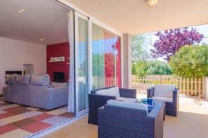 ein Wohnzimmer mit Sofas, Stühlen und Glastüren in der Unterkunft MOSAIC in Sa Ràpita