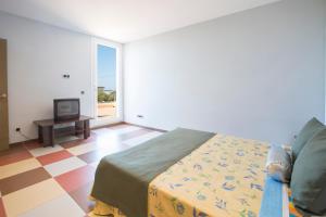 ein Schlafzimmer mit einem Bett und einem Fernseher in einem Zimmer in der Unterkunft MOSAIC in Sa Ràpita