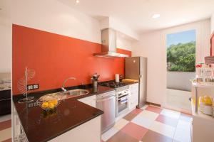 una cocina con una pared de color naranja y blanco en MOSAIC, en Sa Ràpita