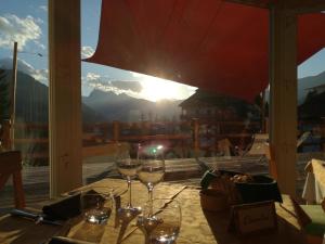 einen Tisch mit Weingläsern und Aussicht in der Unterkunft Hotel Ca' del Bosco in Selva di Cadore