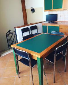 a ping pong table in a kitchen with chairs at La casa di nonna Rosa in Isola delle Femmine