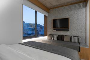 a bedroom with a large bed and a flat screen tv at Ergon House Athens in Athens