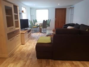 a living room with a couch and a table with chairs at Ferienhaus Am Graseberg in Neinstedt