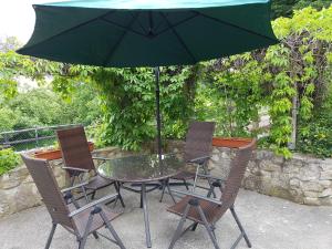 a table and chairs with an umbrella on a patio at Ferienhaus Am Graseberg in Neinstedt