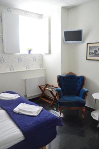 a living room with a blue couch and a chair at Gamla Televerket B&B in Borgholm