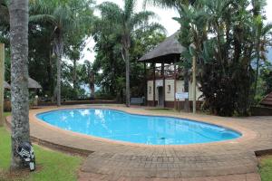 a large blue swimming pool in front of a building at Magoebaskloof Mountain Lodge in Magoebaskloof