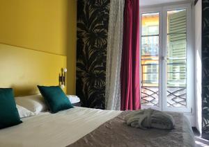 a bedroom with a large bed with a window at Hôtel Le G (ex Le Genève) in Nice