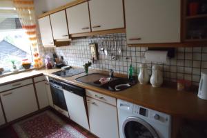 een keuken met een wastafel en een wasmachine bij Privatapartment Henschel in Hannover