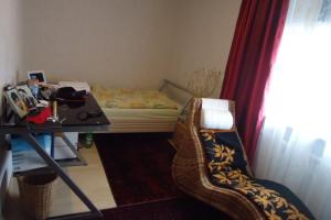 een slaapkamer met een bed, een tafel en een stoel bij Privatapartment Henschel in Hannover