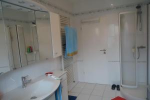 een witte badkamer met een wastafel en een douche bij Privatapartment Henschel in Hannover
