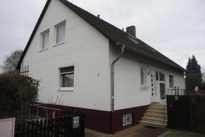 een wit huis met een zwart dak en een trap bij Privatapartment Henschel in Hannover