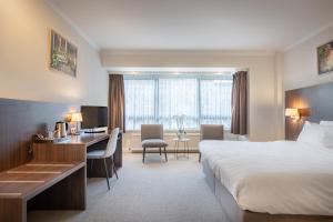 a hotel room with a bed and a desk at Hotel Carlton in Ghent